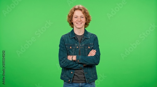 Smiling teenager boy with curly hair against green screen teenager portrait youthful background isolated cheerful