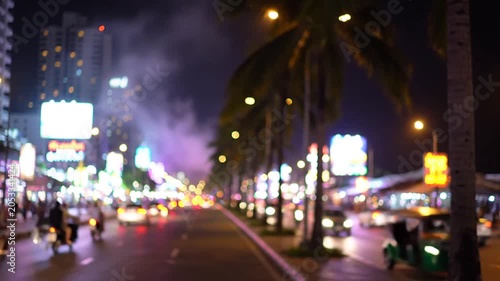 Blurred city street with palm trees and neon at night