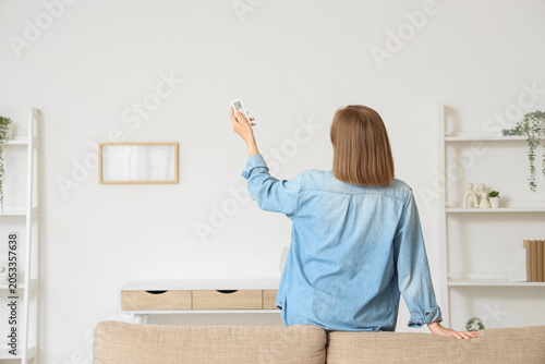 Woman adjusting air conditi...