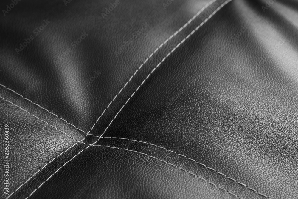 Naklejka premium Black leather upholstery with white stitching detail, luxury furniture material texture, modern interior design element