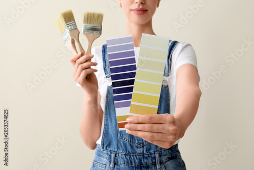 Woman holding paint brushes...