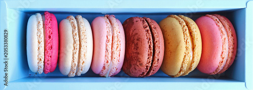 Top view shot of beautiful colored Macaron pastries assortment in light blue box