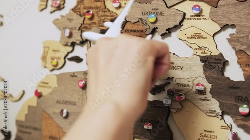 Woman exploring travel concept with plane above wooden map.