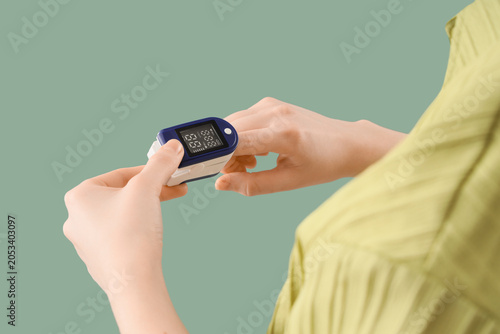 Schilderij op canvas Person using fingertip pulse oximeter for oxygen saturation and heart rate monit