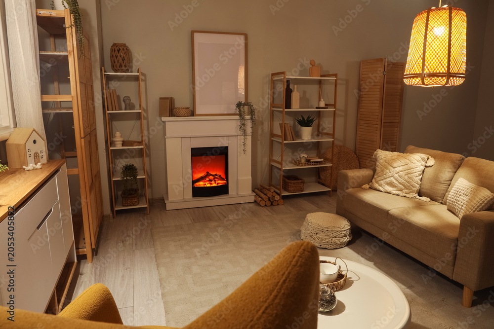 Obraz premium Cozy living room interior with electric fireplace, comfortable sofa, and modern home decor elements