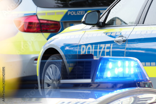 Deutsche Polizeiautos mit Blaulicht als Symbol für Gewalt und Kriminalität in Deutschland