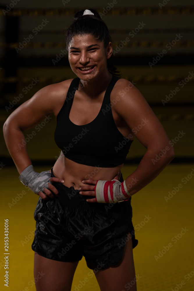 Naklejka premium Smiling Female Boxer In Gym Training With Hand Wraps Showing Strength And Confidence