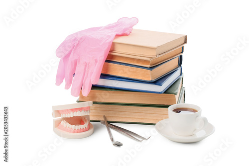 Фотография Dental education and study materials with jaw model, tools, books, and coffee fo