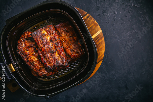 Tableau sur toile Modern cooking - preparing juicy spare ribs with honey sauce in airfryier, BBQ m
