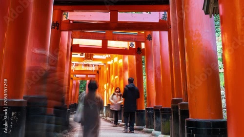 Time-lapse of crowd of tourists walking through the famous red Senbon Torii gates at Fushimi Inari Taisha Shrine in Kyoto, Japan. Popular landmark in Japan.