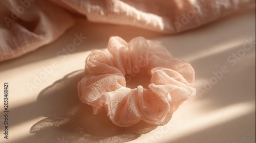 Delicate peach fabric hair accessory with soft shadows and diffused light