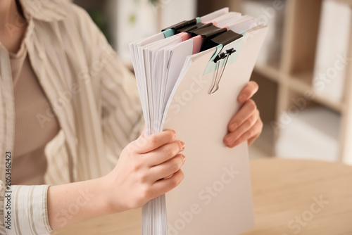 Woman holding stack of docu...