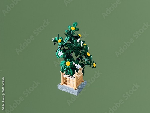 The green background in the image shows plastic flowers in a green wooden box. The flowers are white and yellow, made of plastic, and are used for decoration in homes or shops, offering a colorful dis