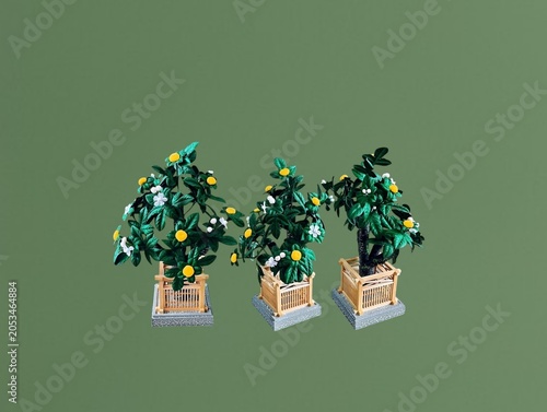 The green background in the image shows plastic flowers in a green wooden box. The flowers are white and yellow, made of plastic, and are used for decoration in homes or shops, offering a colorful dis