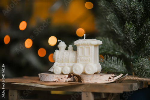 Unique handmade soy wax candles, cozy room with wooden decorations and Christmas lights in the background