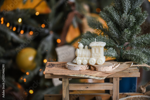 Unique handmade soy wax candles, cozy room with wooden decorations and Christmas lights in the background