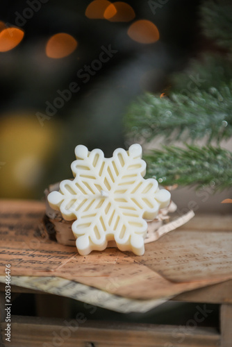 Unique handmade soy wax candles, cozy room with wooden decorations and Christmas lights in the background