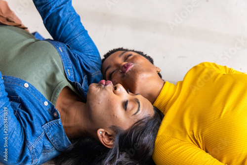 Blue denim jacket and green ribbed top with yellow ribbed sleeve are lying on pale floor