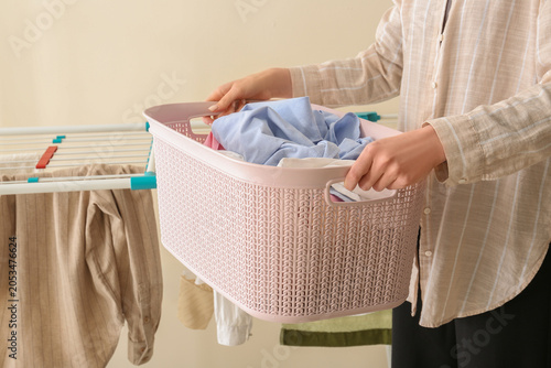 Woman holding pink laundry ...