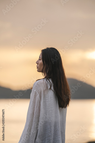 夕暮れの海にいる女性