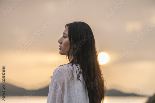 夕暮れの海にいる女性