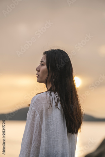 夕暮れの海にいる女性