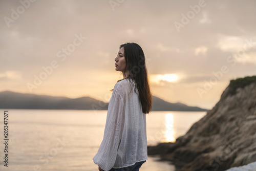夕暮れの海にいる女性
