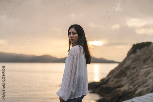 夕暮れの海にいる女性