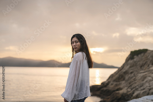夕暮れの海にいる女性