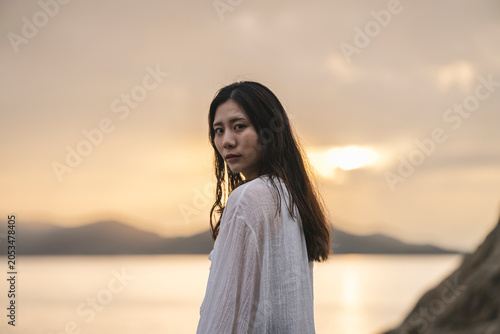 夕暮れの海にいる女性