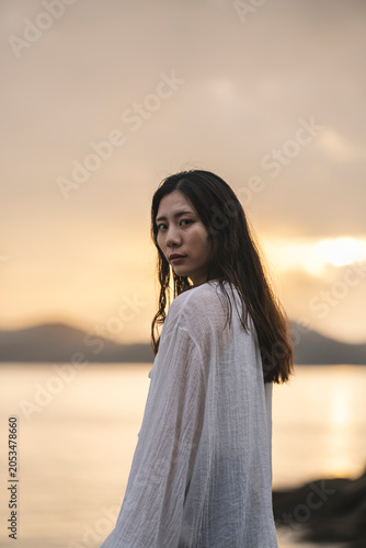 夕暮れの海にいる女性