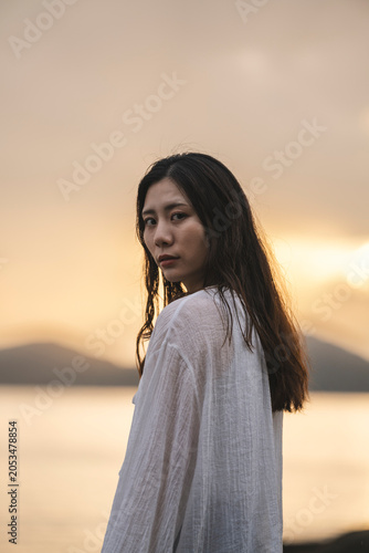 夕暮れの海にいる女性