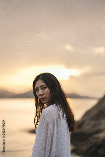 夕暮れの海にいる女性