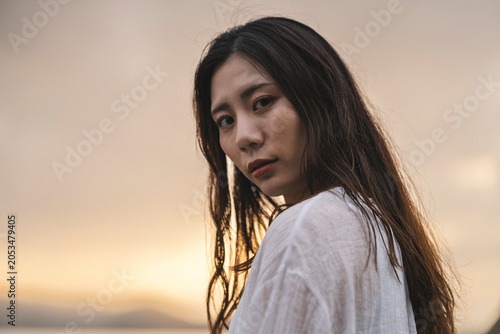 夕暮れの海にいる女性