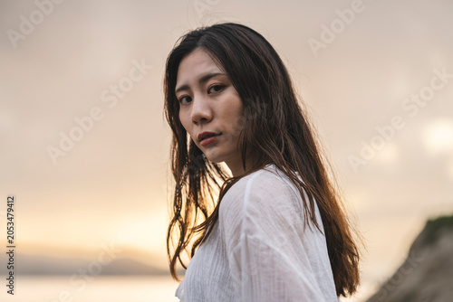 夕暮れの海にいる女性