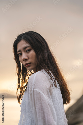 夕暮れの海にいる女性