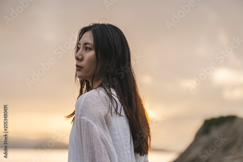 夕暮れの海にいる女性