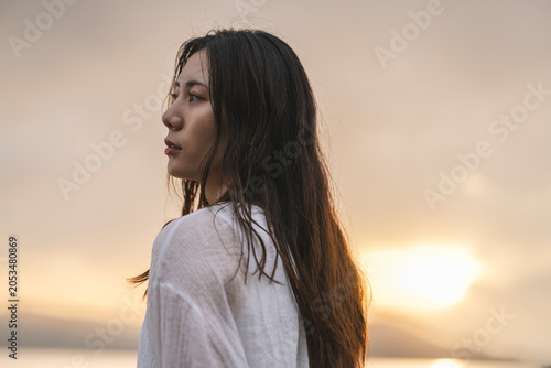 夕暮れの海にいる女性