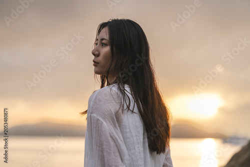 夕暮れの海にいる女性