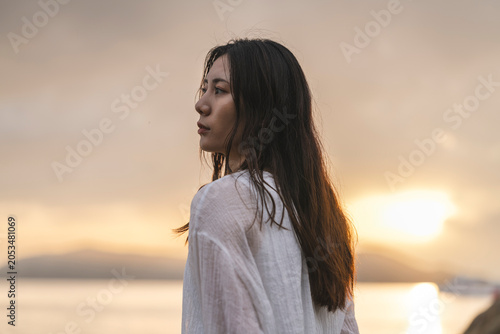 Принти на полотні 夕暮れの海にいる女性