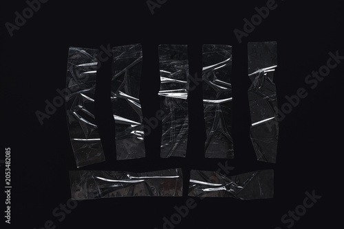 Schilderij op canvas Clear adhesive tape strips with wrinkles and reflections on a dark black backgro