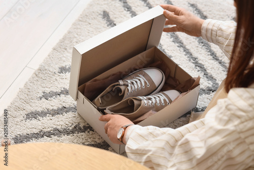 Fotografie Unboxing new beige canvas sneakers in cardboard box, online shopping delivery an