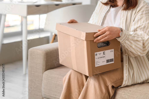 Woman holding cardboard box...