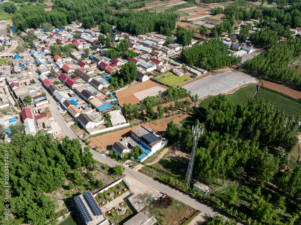 Fototapeta premium Aerial view of rural residential area with farmland and forest landscape