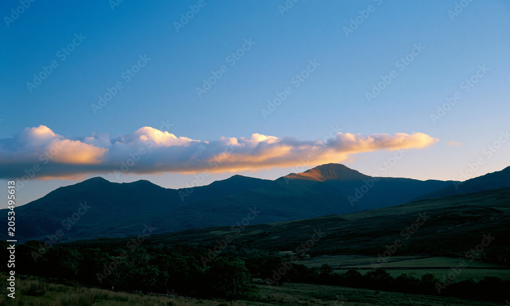 Fototapeta premium a natural landscape showcasing a sky that graduates from deep blue at the top to a lighter hue, then a horizontal formation of clouds
