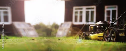 Panel kuchenny z motywem Lawn mower cut grass. Garden work. Electric Rotary lawn mower machine. Panorama, banner