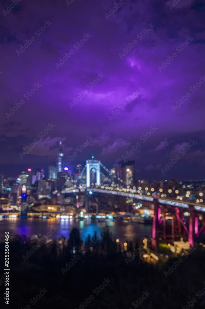 Fototapeta premium Night city skyline with glowing bridge lights and purple dark sky over the water reflection in the harbor