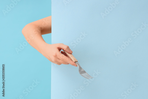 Hand holding a metal fork w...