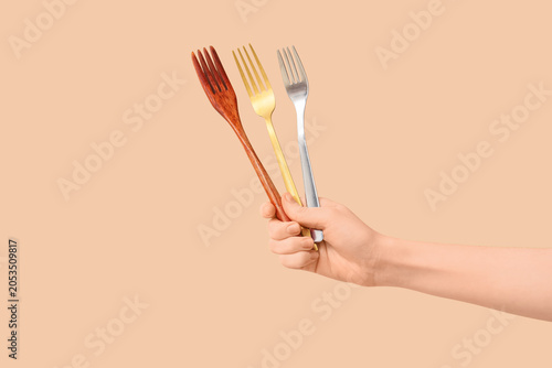Hand holding three forks: w...