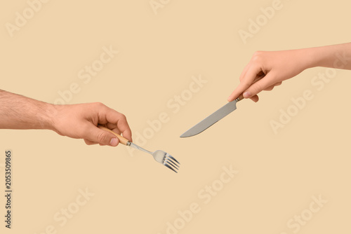 Fotografie Two hands holding fork and knife for eating, meal preparation, and dining experi